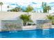 Close up of the pool and waterfall features framed by palms and cacti for a unique backyard appeal at 8549 E Indianola Ave, Scottsdale, AZ 85251