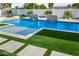 Gorgeous backyard pool featuring lovely waterfalls and a modern turf and tile design surrounding the water at 8549 E Indianola Ave, Scottsdale, AZ 85251