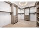 Spacious walk-in closet with custom shelving, drawers, and elegant chandelier at 8549 E Indianola Ave, Scottsdale, AZ 85251
