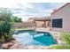Private backyard pool with rock accents, covered patio, and well-maintained landscaping at 8635 W Country Gables Dr, Peoria, AZ 85381