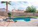 Private pool surrounded by rock features, lush greenery, and a spacious patio at 8635 W Country Gables Dr, Peoria, AZ 85381