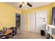 This bedroom features yellow walls, carpet flooring, and a closet with mirrored doors at 9343 W Quail Ave, Peoria, AZ 85382