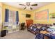 This bedroom features yellow walls, carpet flooring, a desk, and a ceiling fan at 9343 W Quail Ave, Peoria, AZ 85382