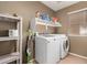 Well-equipped laundry room with modern washer and dryer, plus ample storage shelving at 9343 W Quail Ave, Peoria, AZ 85382