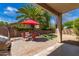 Outdoor patio area with a red umbrella over a table and chairs, perfect for relaxing at 9343 W Quail Ave, Peoria, AZ 85382
