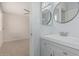 Bathroom with modern vanity, round mirror, and open doorway to a bedroom at 9609 N 44Th Ave, Glendale, AZ 85302