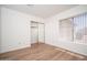 Bright bedroom featuring wood-look floors, a closet with mirror doors, and a window with blinds at 10808 W Ruth Ave, Peoria, AZ 85345