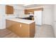 Functional kitchen featuring wood cabinets, white appliances, and breakfast bar seating at 10808 W Ruth Ave, Peoria, AZ 85345