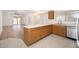Bright kitchen with wood cabinets, light countertops and tile flooring overlooking the living room at 10808 W Ruth Ave, Peoria, AZ 85345