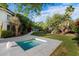 Serene backyard featuring a spa surrounded by green grass, lush trees, and landscaping at 11331 E Cochise Dr, Scottsdale, AZ 85259