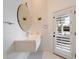 Bright bathroom featuring a unique round mirror and a floating sink and cabinet at 11331 E Cochise Dr, Scottsdale, AZ 85259
