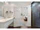 Stylish bathroom featuring wood floors, a floating vanity with double mirrors, and a glimpse into the primary bedroom at 11331 E Cochise Dr, Scottsdale, AZ 85259