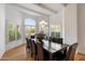 Formal dining room with large table, wood floors, and a large window with shutters at 11331 E Cochise Dr, Scottsdale, AZ 85259