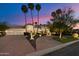 Elegant home featuring desert landscaping, a paver driveway, and a three-car garage at twilight at 11331 E Cochise Dr, Scottsdale, AZ 85259