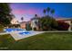 Spacious backyard with pool, spa, and well-manicured lawn, ideal for outdoor living and entertaining in a private setting at 11331 E Cochise Dr, Scottsdale, AZ 85259