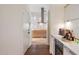 Bright kitchen featuring an arched entryway, white cabinets, and stainless steel appliances at 11331 E Cochise Dr, Scottsdale, AZ 85259