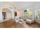 Bright living room features large windows, wood floors, and modern white sofas at 11331 E Cochise Dr, Scottsdale, AZ 85259