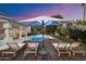 Relaxing lounge area by the pool with comfortable seating, umbrella, and fire pit, ideal for outdoor entertaining and enjoying the sunset at 11331 E Cochise Dr, Scottsdale, AZ 85259