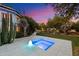 Inviting pool and spa area with lush landscaping and ambient lighting, perfect for relaxation and enjoying the desert evenings at 11331 E Cochise Dr, Scottsdale, AZ 85259