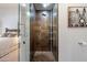 Modern bathroom boasting a glass enclosed shower with bronze tiling and built in storage at 11331 E Cochise Dr, Scottsdale, AZ 85259