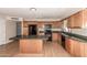 Bright kitchen featuring wood cabinets, dark countertops, and a center island with black appliances at 1203 E Bishop Dr, Tempe, AZ 85282