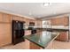 Modern kitchen featuring wood cabinets, black appliances, and an island bar area at 1203 E Bishop Dr, Tempe, AZ 85282