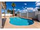 Inviting backyard pool surrounded by clear blue sky, palms, and a white block fence at 1203 E Bishop Dr, Tempe, AZ 85282