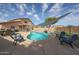 Backyard with a pool, a sunshade, and a patio offers outdoor relaxation and entertainment at 12513 W Dreyfus Dr, El Mirage, AZ 85335