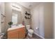 Well-lit powder room featuring vanity with modern fixtures and decorative shelving at 12513 W Dreyfus Dr, El Mirage, AZ 85335