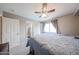 Comfortable bedroom featuring a ceiling fan, large window, and neutral decor at 12513 W Dreyfus Dr, El Mirage, AZ 85335