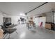 Spacious garage with epoxy flooring and various storage solutions. A seating area offers space to relax at 12513 W Dreyfus Dr, El Mirage, AZ 85335