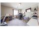 Home office features two wooden desks, carpet floors, storage shelves, and a mounted TV on the wall at 12513 W Dreyfus Dr, El Mirage, AZ 85335