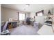 Home office features two wooden desks, carpet floors, a large TV and built-in storage at 12513 W Dreyfus Dr, El Mirage, AZ 85335