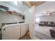 Laundry room with modern washer and dryer units, wire shelving, and convenient access to the living area at 12513 W Dreyfus Dr, El Mirage, AZ 85335