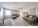 Bright living room with a comfortable sectional sofa, large windows, and view of kitchen area at 12513 W Dreyfus Dr, El Mirage, AZ 85335