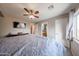 Main bedroom boasts a ceiling fan, television, and ensuite bathroom access at 12513 W Dreyfus Dr, El Mirage, AZ 85335