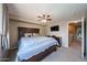Spacious main bedroom featuring a ceiling fan, TV, and access to an adjoining bathroom at 12513 W Dreyfus Dr, El Mirage, AZ 85335