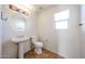 Stylish bathroom featuring a pedestal sink, modern fixtures, and neutral-toned tile flooring at 12845 W Milton Dr, Peoria, AZ 85383