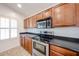 Kitchen features stainless steel oven and microwave, dark countertops, and natural wood cabinets at 12845 W Milton Dr, Peoria, AZ 85383