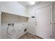 Functional laundry room featuring neutral paint, tile flooring, a storage shelf, and access to the exterior at 12845 W Milton Dr, Peoria, AZ 85383