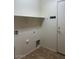 Bright laundry room with shelving, tile floors, and utility connections for washer and dryer at 12845 W Milton Dr, Peoria, AZ 85383