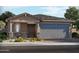 Charming single-story home featuring a gray-toned two-car garage, stone accents, and desert landscaping at 131 N 175Th Ln, Goodyear, AZ 85338