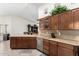 A bright kitchen featuring wood cabinets, granite countertops, and stainless steel appliances at 16083 W Cambridge Ave, Goodyear, AZ 85395