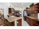A well-lit kitchen featuring wooden cabinets, tile floors, granite countertops and modern appliances at 16083 W Cambridge Ave, Goodyear, AZ 85395