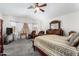 A spacious main bedroom featuring a sitting area, a ceiling fan, and neutral paint colors at 16083 W Cambridge Ave, Goodyear, AZ 85395