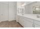 Bright bathroom with a double vanity, tile floors, and a large mirror at 16494 W Creedance Blvd, Surprise, AZ 85387