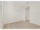 A simple bedroom featuring neutral carpet, white walls, and an open doorway at 16494 W Creedance Blvd, Surprise, AZ 85387