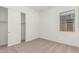 Bright bedroom with plush carpet, window, and closet with sliding doors at 16494 W Creedance Blvd, Surprise, AZ 85387