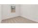 A simple bedroom featuring neutral carpet, white walls, and a window view at 16494 W Creedance Blvd, Surprise, AZ 85387