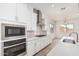 Close-up of kitchen with stainless appliances and white cabinets and tile backsplash at 16494 W Creedance Blvd, Surprise, AZ 85387